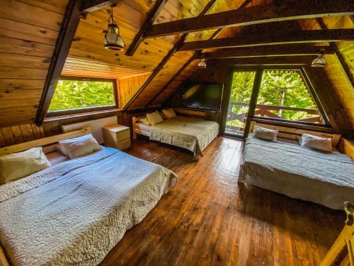 um quarto com 2 camas num chalé de madeira em Kashubia Cottage em Przewóz