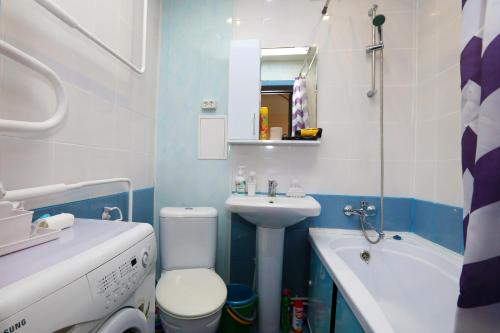a bathroom with a toilet and a sink and a bath tub at Уютная квартира на Сибирской 44 in Novosibirsk
