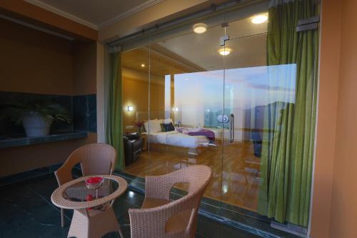 a living room with a couch and a table and chairs at The Byke Nature Vilas Pure Veg in Shimla