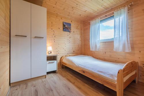 Habitación pequeña con cama y ventana en DOMKI ANITA, en Zawóz