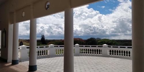 a view from the porch of a house with a white fence at Royal Orchid Brindavan Garden Mysore in Belagula