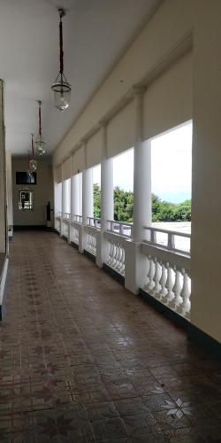 an empty room with white columns and windows at Royal Orchid Brindavan Garden Mysore in Belagula
