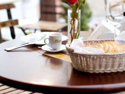 a table with a basket of bread and a cup of coffee at Mercure Sao Paulo Alamedas in Sao Paulo