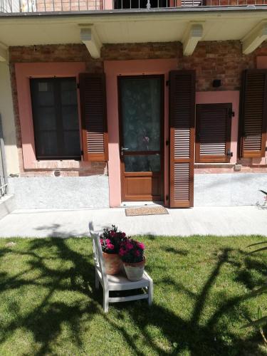 a house with a potted plant on a chair in the grass at A cà ed Franca e Giaco in La Morra
