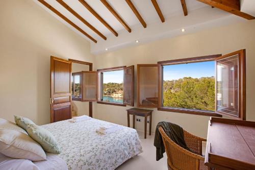 サンタニーにあるVilla Cala Figueraのベッドルーム1室(ベッド1台、窓2つ付)