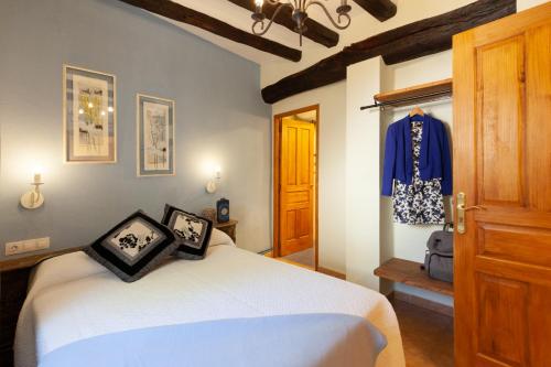 Un dormitorio con una cama y una camisa azul en una ventana en Cal Salut Priorat, Casa y apartamento, en Gratallops