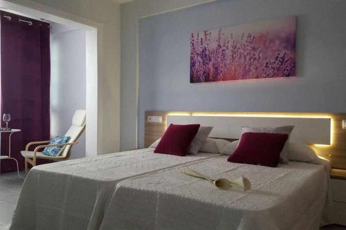 プエルト・デ・ラ・クルスにあるApartamento con Terraza y Piscina Cのベッドルーム(赤い枕の大きな白いベッド付)