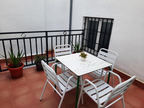 a white table and chairs on a balcony at Apartamentos Clavero 10 in Plasencia