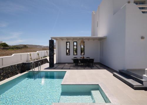 a villa with a swimming pool and a house at La Ponta Villas & Suites in Akrotiri