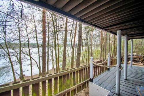 a wooden porch with a view of a river at Sielanka Mazury in Szczytno
