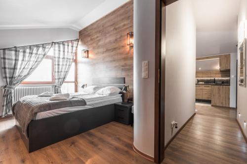 sypialnia z łóżkiem i drewnianą ścianą w obiekcie Apartament Top Zakopane w Zakopanem