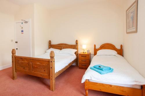 a bedroom with two beds and a blue towel on the bed at Balintore Inn in Balintore