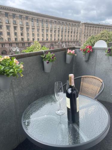 a bottle of wine sitting on a table with a glass at Freddies apartment in Kyiv