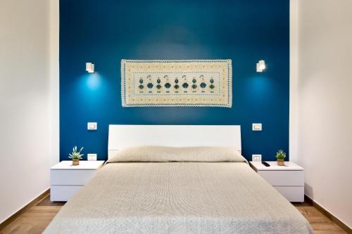 1 dormitorio azul con 1 cama y 2 mesitas de noche en Sunshine apartment, en Su Forti