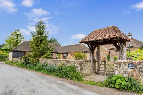 a stone house with a wooden gate and a fence at Dyke Farm Barn near Brighton by Huluki Sussex Stays in Brighton & Hove