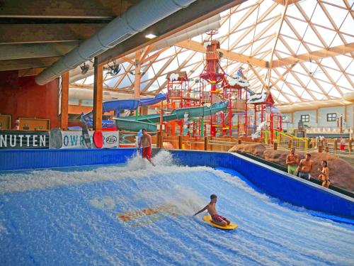 2 personnes sur des planches de surf dans un parc aquatique intérieur dans l'établissement The Summit at Massanutten Resort by TripForth, à McGaheysville