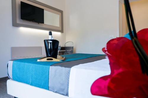 a room with a bed and a red chair and a television at La dimora del cavatore in Favignana
