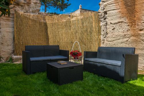 two chairs and a table in the grass at La dimora del cavatore in Favignana