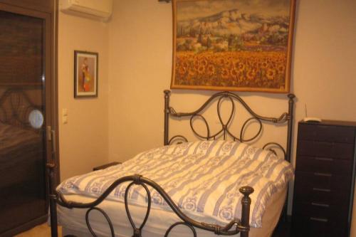a bed in a bedroom with a painting on the wall at Kyparrisia, Pelloponese Villa with Mountain and Sea Views in Glikorrízion