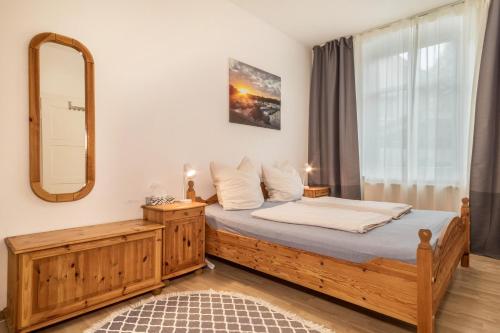 um quarto com uma cama de madeira e um espelho em Apartment Tuna em Sigmarszell