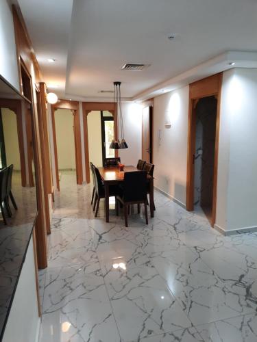 a dining room with a table and chairs on a marble floor at appart hotel puerto marino in Al Hoceïma