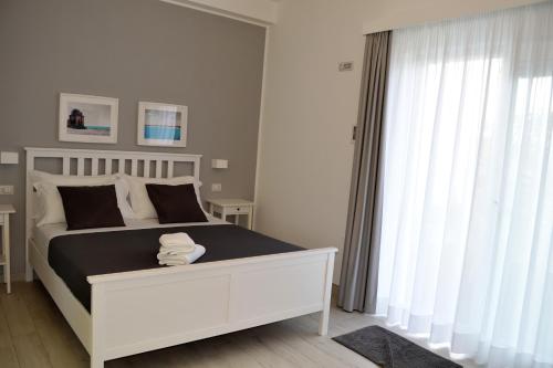 a bedroom with a large white bed with a window at Arneo Terra del Sole in Torre Lapillo
