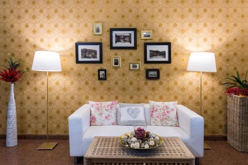 a living room with a white couch and two lamps at ROMANTIK HOTEL ELEONORA in Tábor