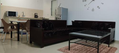 un soggiorno con divano nero e tavolo di Dar Lebharr Kélibia a Kelibia