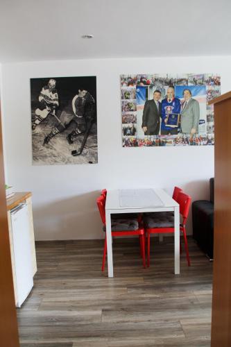 a dining room with a white table and red chairs at Rudi Hiti's Guest House in Bled