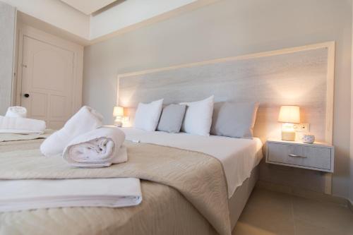 a bedroom with a large bed with towels on it at Sirena Apartments in Agia Pelagia