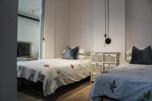 a bedroom with two beds with white sheets and blue pillows at Ivy Lalzi Bay Beach House in Durrës