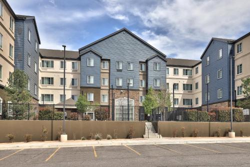 a row of apartment buildings with a parking lot at Staybridge Suites - Albuquerque Airport by IHG in Albuquerque