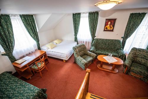 a living room with a bed and a table and chairs at ROMANTIK HOTEL ELEONORA in Tábor