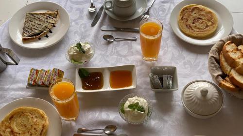 a table with plates of food and glasses of orange juice at Riad Aguaviva in Marrakech