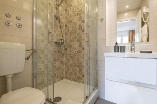 La salle de bains est pourvue d'une douche, de toilettes et d'un lavabo. dans l'établissement Apartments Sentic, à Neum