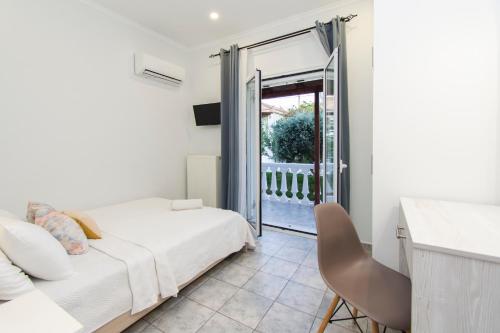 a bedroom with a bed and a sliding glass door at Villas Margaris in Kalamaki