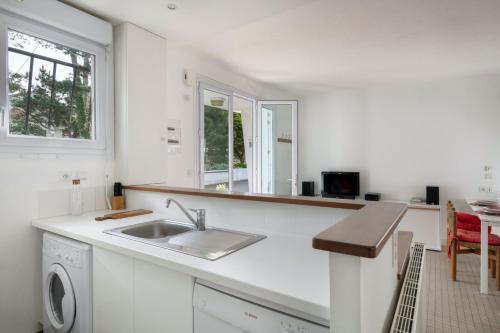 uma cozinha branca com um lavatório e um balcão em Votre cocon a proximite de la plage de La Baule em La Baule