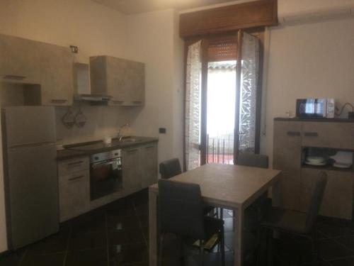 uma cozinha com uma mesa de madeira e uma cozinha com uma mesa e cadeiras em Ca' L'Archetto intero appartamento centro Cremona em Cremona