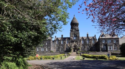 an old building with a clock tower on top at Hinsley Hall in Leeds