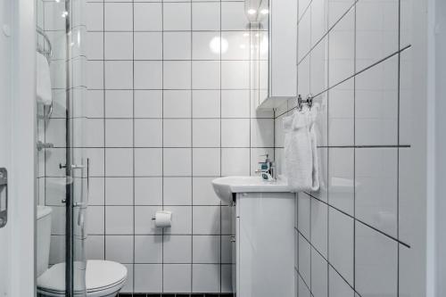 Baño blanco con aseo y lavamanos en Part-Time Home Rotebro, en Rotebro