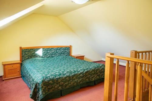 a bedroom with a bed with a green comforter at ROMANTIK HOTEL ELEONORA in Tábor