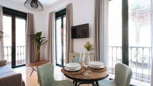 a living room with a table and chairs and a tv at Chiqui and Vicente Bright Apartment in Seville