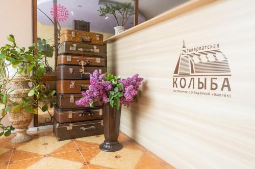 a vase of flowers next to a pile of suitcases at Zakarpatska Kolyba in Odesa