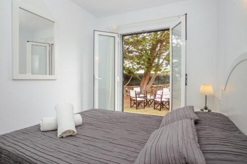 1 dormitorio con cama y ventana grande en Apartmento con terraza privada-c1, en Ciutadella