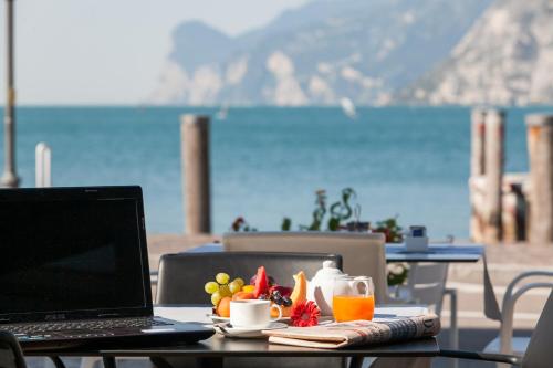 a laptop computer sitting on a table with a view of the ocean at Hotel Lago Di Garda in Nago-Torbole