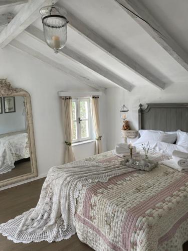 a white bedroom with a large bed and a mirror at Robinson house Leticia in Čunski