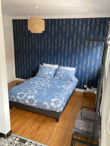 - une chambre avec un lit et un mur bleu dans l'établissement Le Treize-Mer, à Le Portel