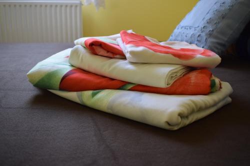 a pile of blankets sitting on top of a bed at Pokoje U Emilii in Kąty Rybackie