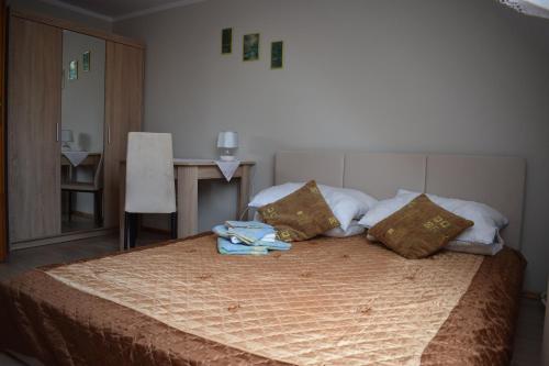 a bedroom with a bed with a blanket and pillows at Pokoje U Emilii in Kąty Rybackie