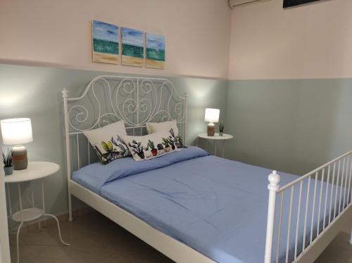 Schlafzimmer mit einem Bett mit blauer Decke in der Unterkunft Nonno Rocco in Castro di Lecce